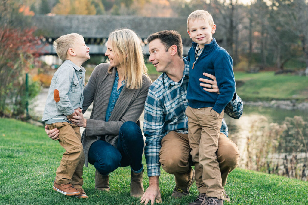 woodstock vermont family photo session: parents kneeling with kids in front of covered bridge