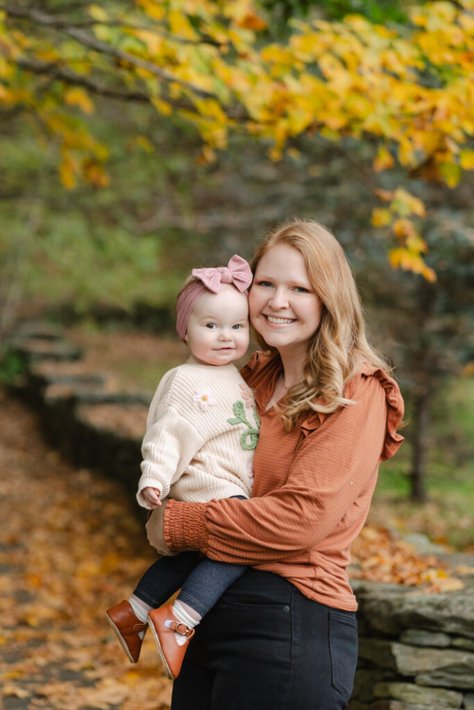 mother smiling at camera with baby during woodstock vermont fall family photo session