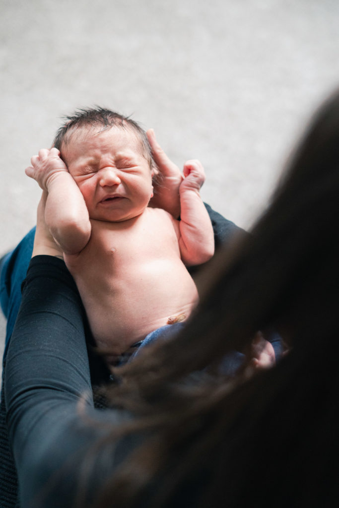 baby crying on mom's lap