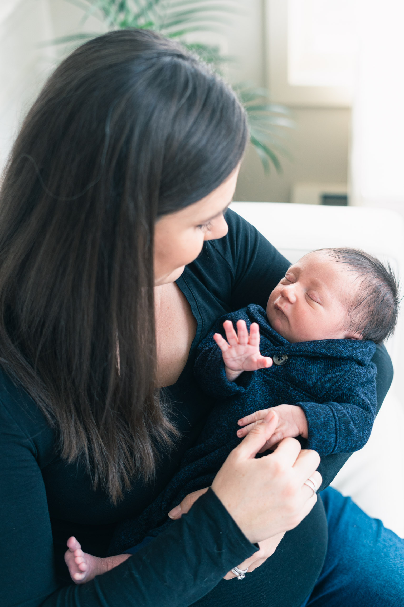 mother holding newborn looking down