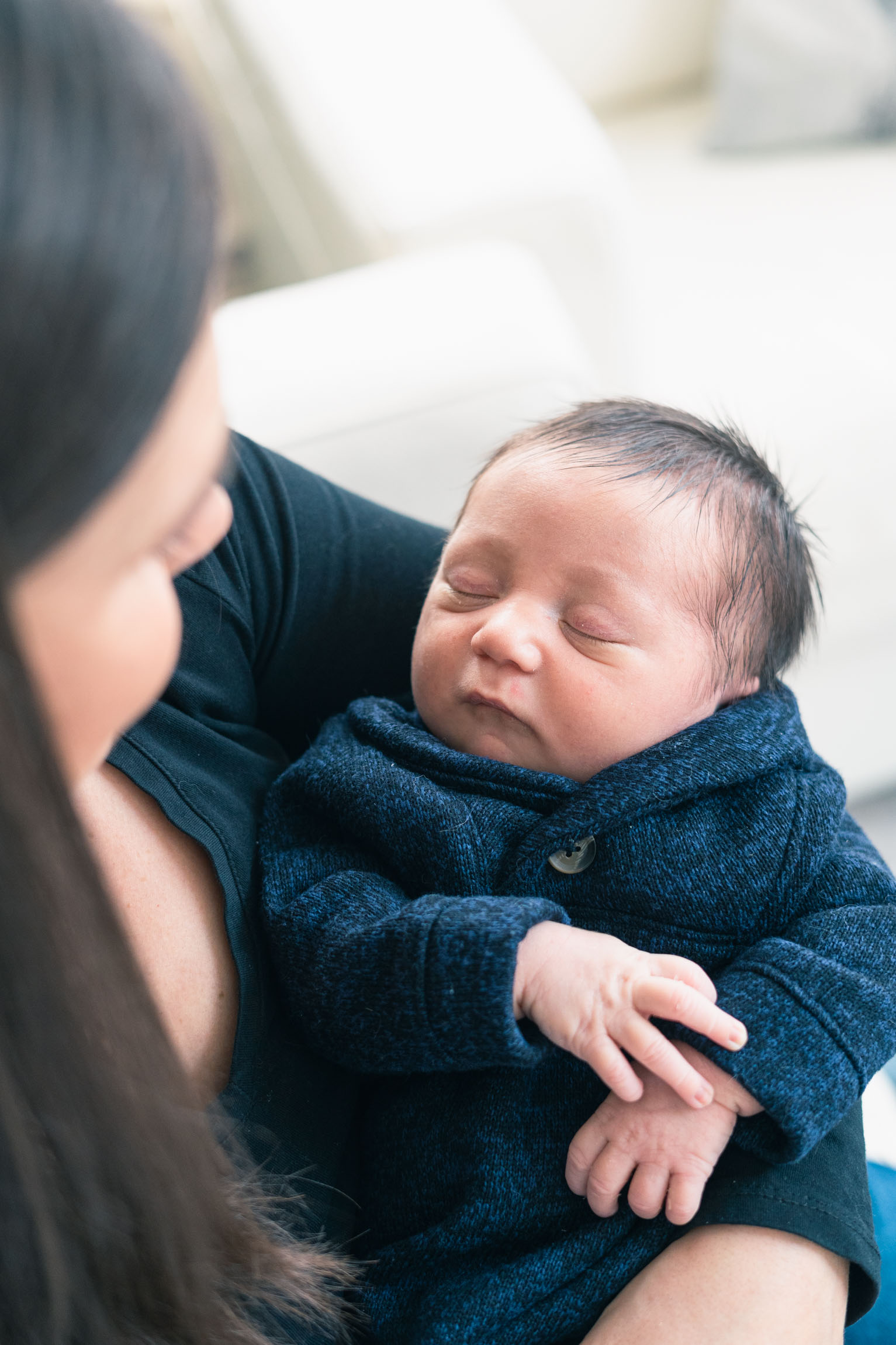 mother holding newborn looking down