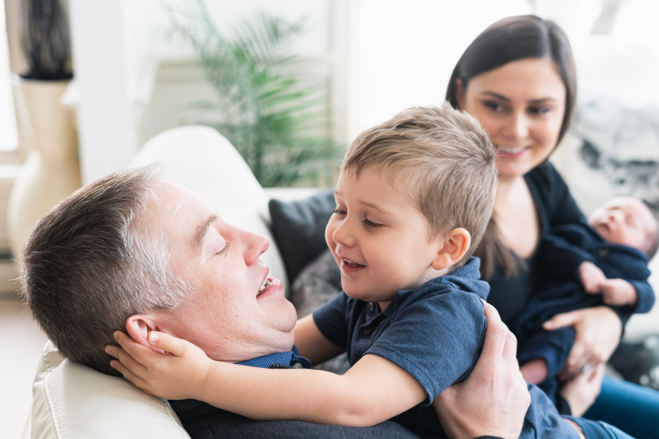 father and son playing with mother and baby in back