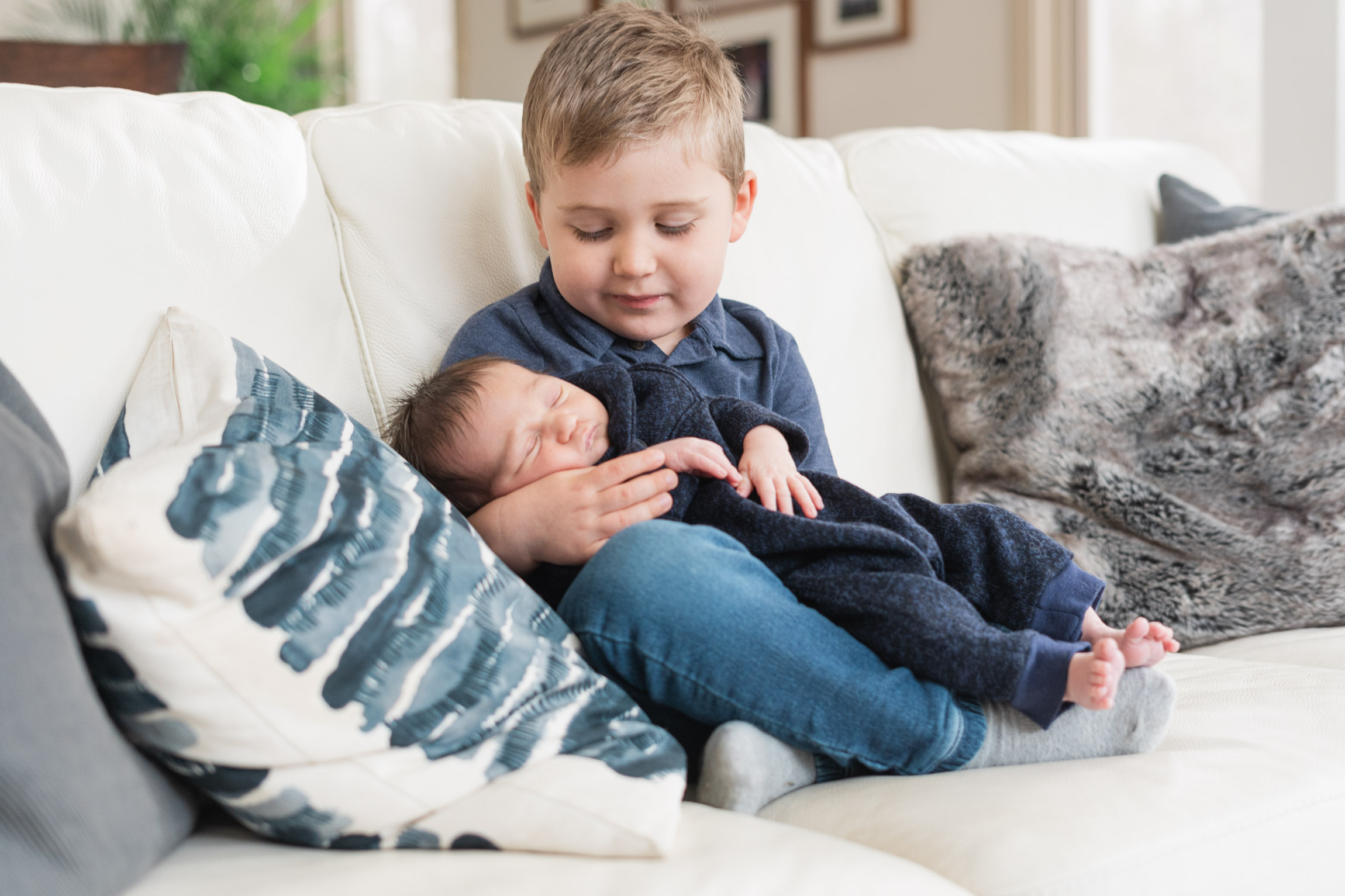 brother holding baby sibling newborn