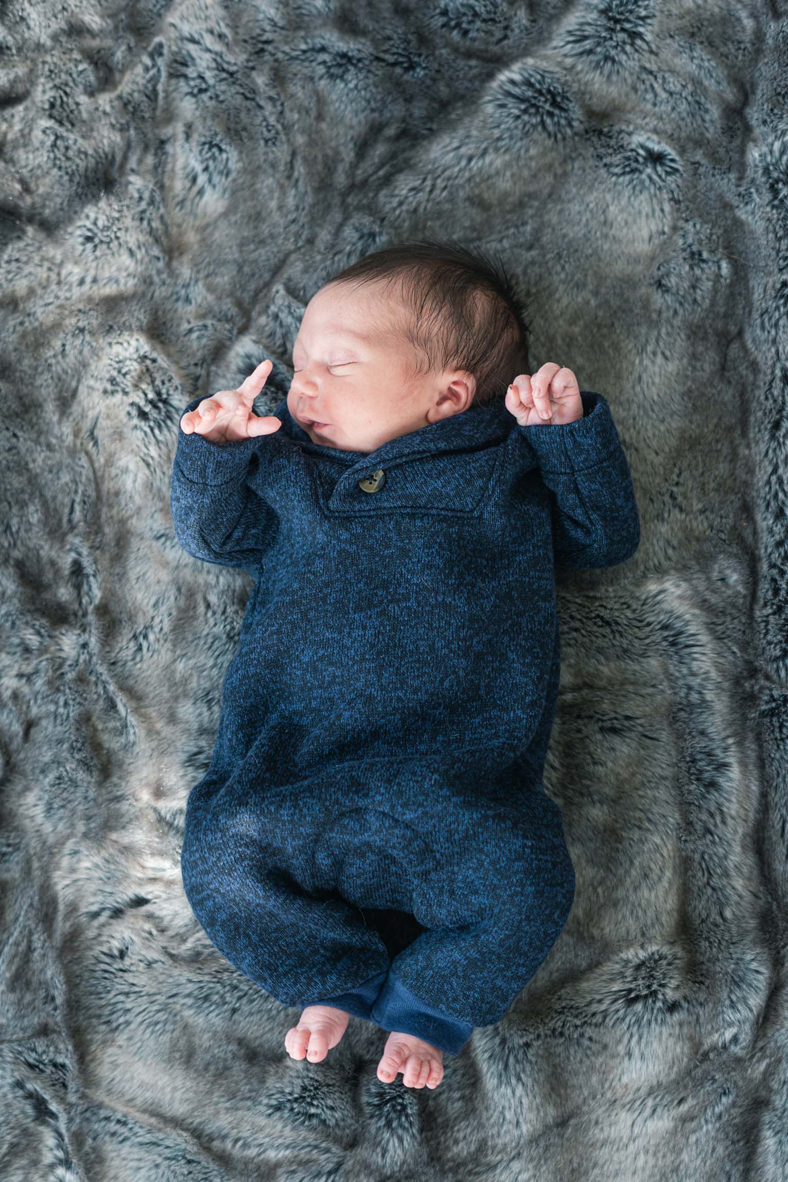 newborn laying on furry blanket