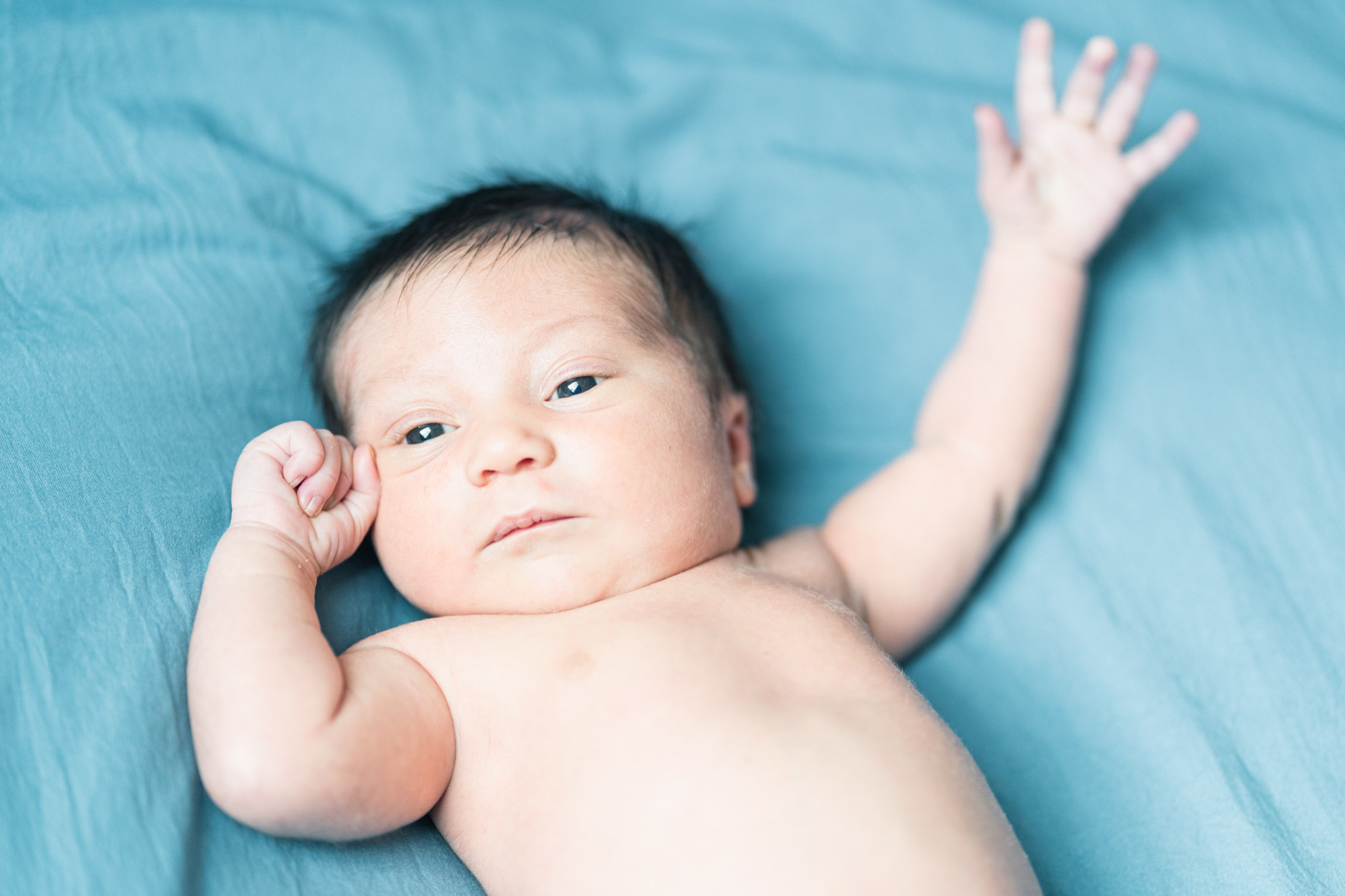 newborn doing cute pose on blanket
