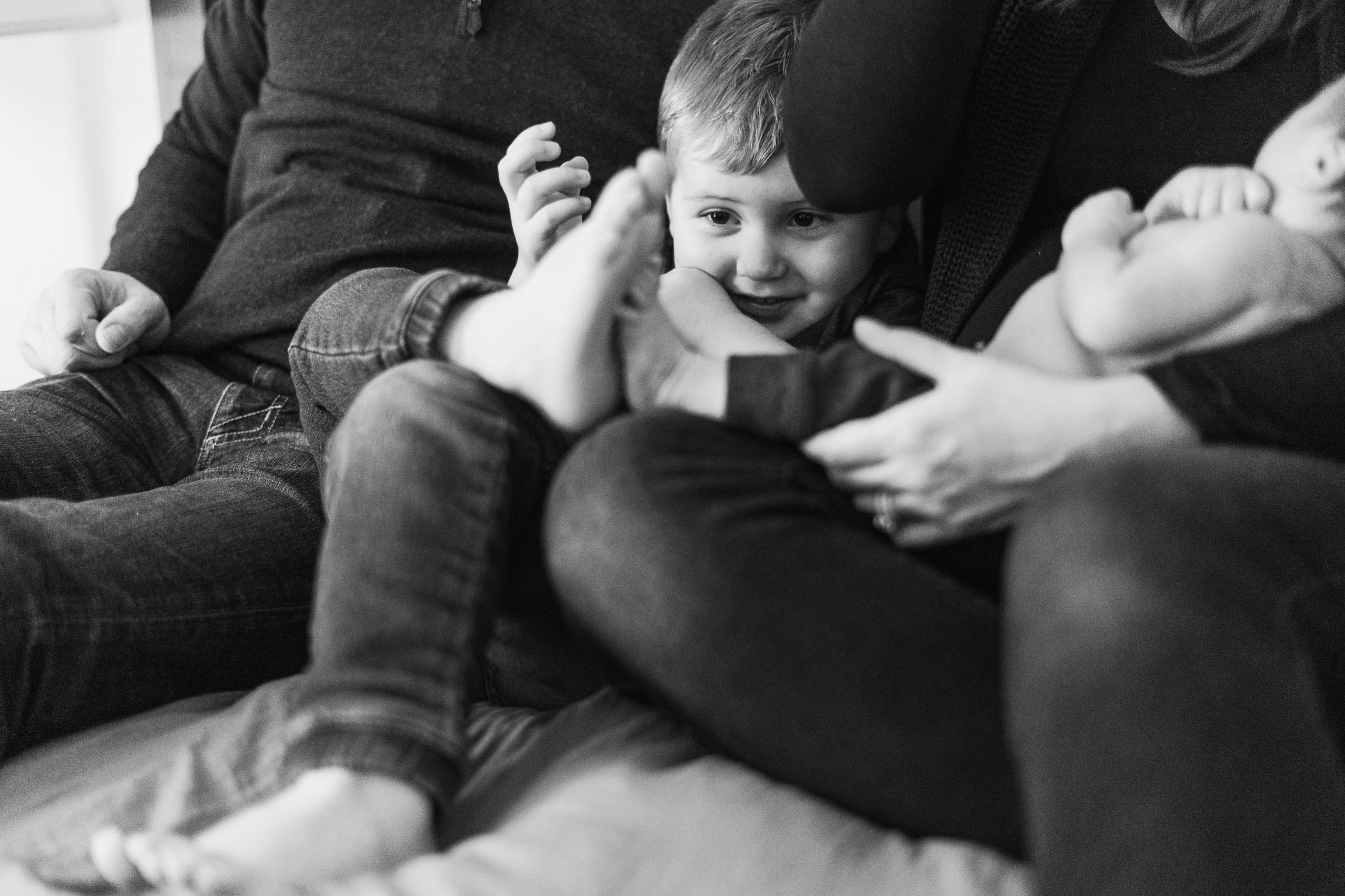young boy snuggling with parents and baby brother