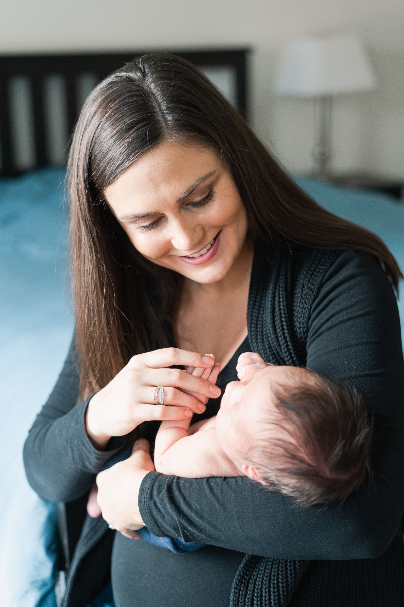 mother cradling baby, sitting in window light