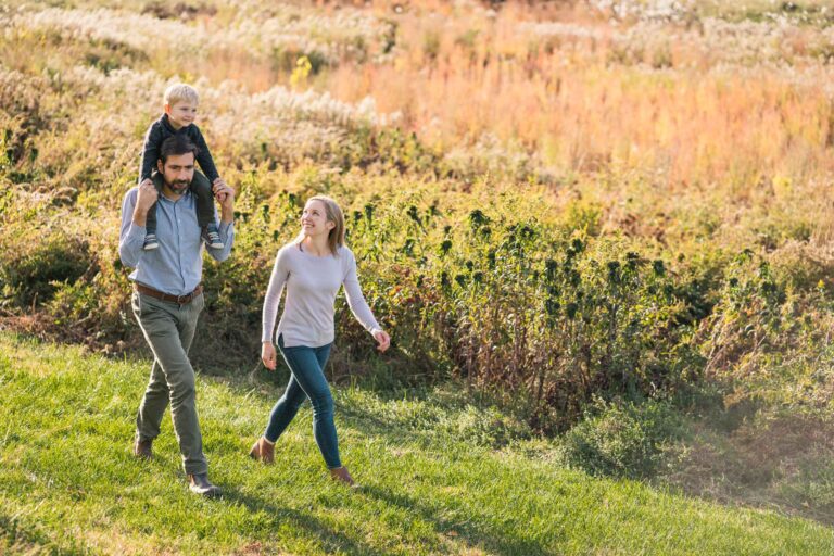 parents walking near field at dartmouth organic farm, hanover nh