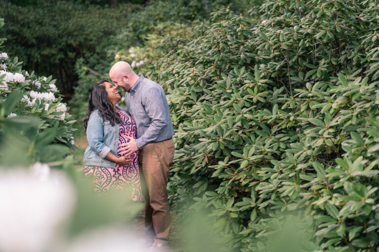 couple standing and laughing amidst rhododendrons at the fells, newbury nh