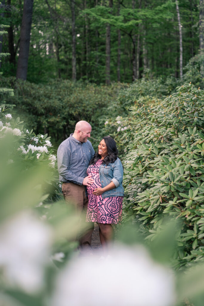 couple walking amidst rhododendrons at the fells, newbury nh