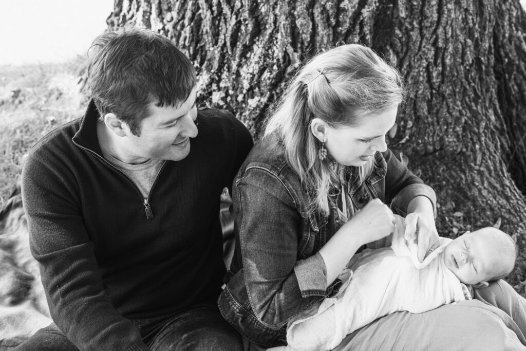 parents outside against tree with baby
