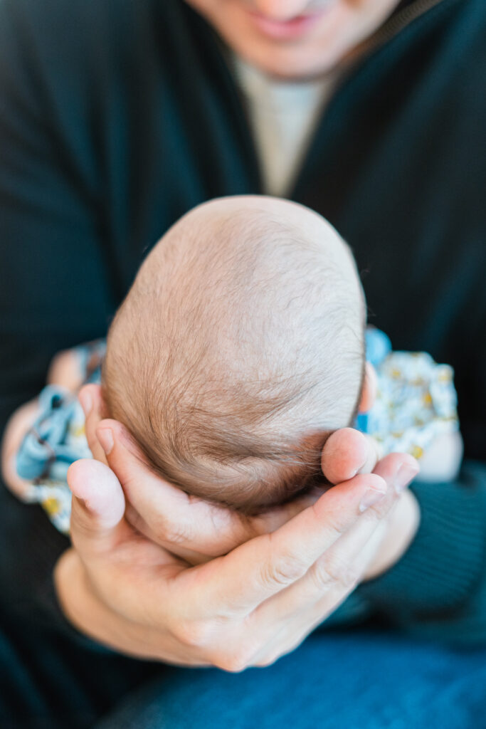 dads hands holding tiny baby