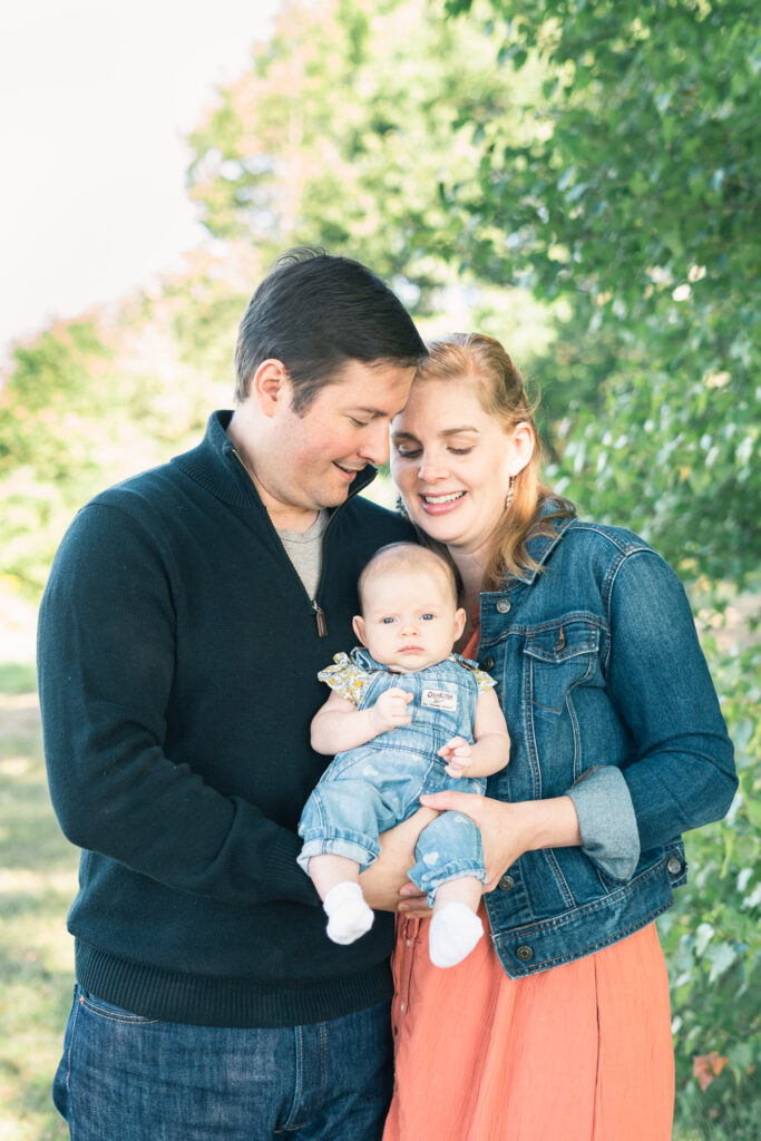 parents holding baby trees behind htem