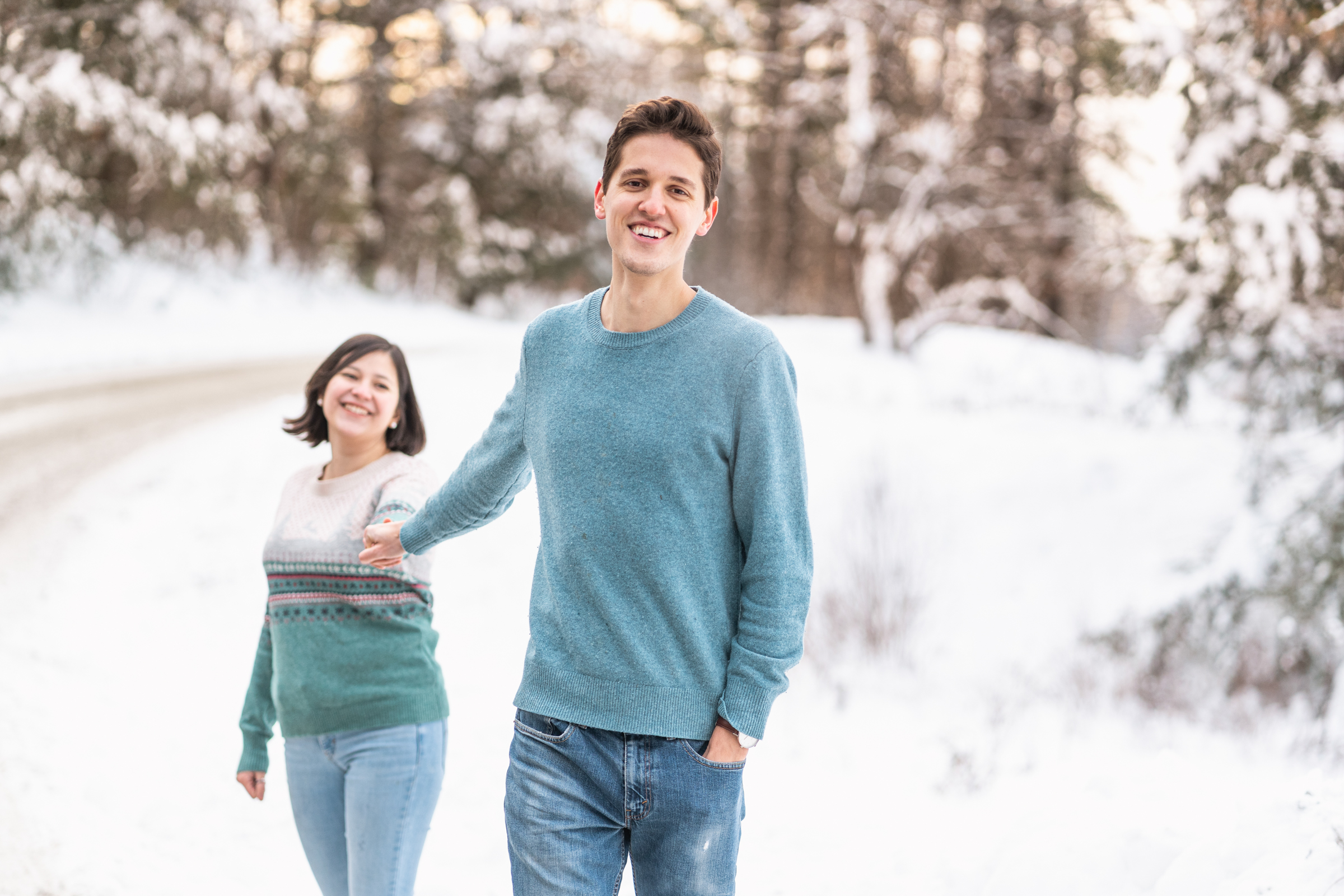 couple walking toward camera with snowy scene behind them