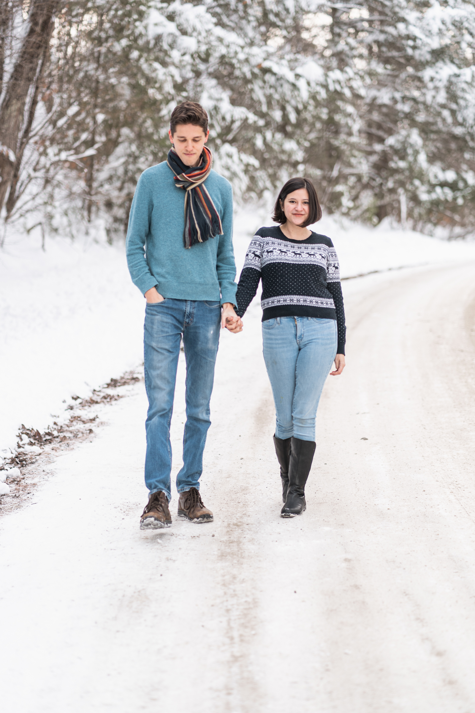 couple walking down snowy, country road in new hampshire