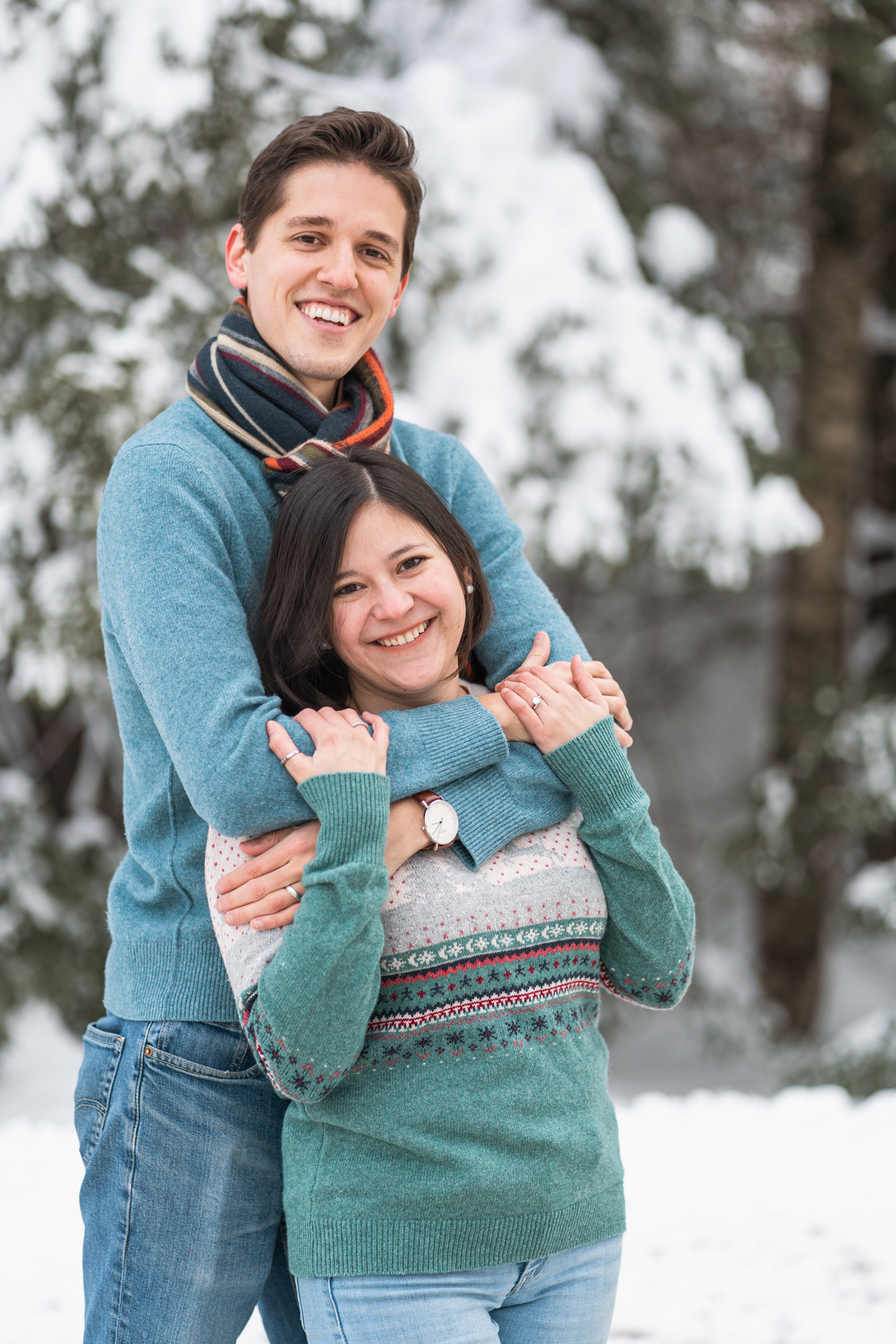 couple posing with snow in background facing camera