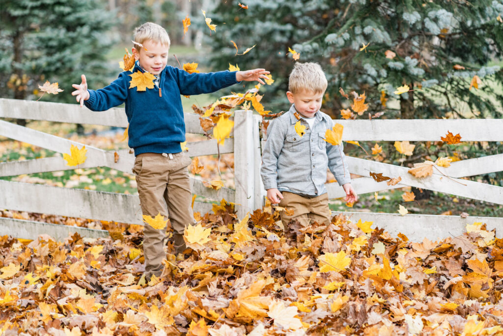 kids playing in fall leaves