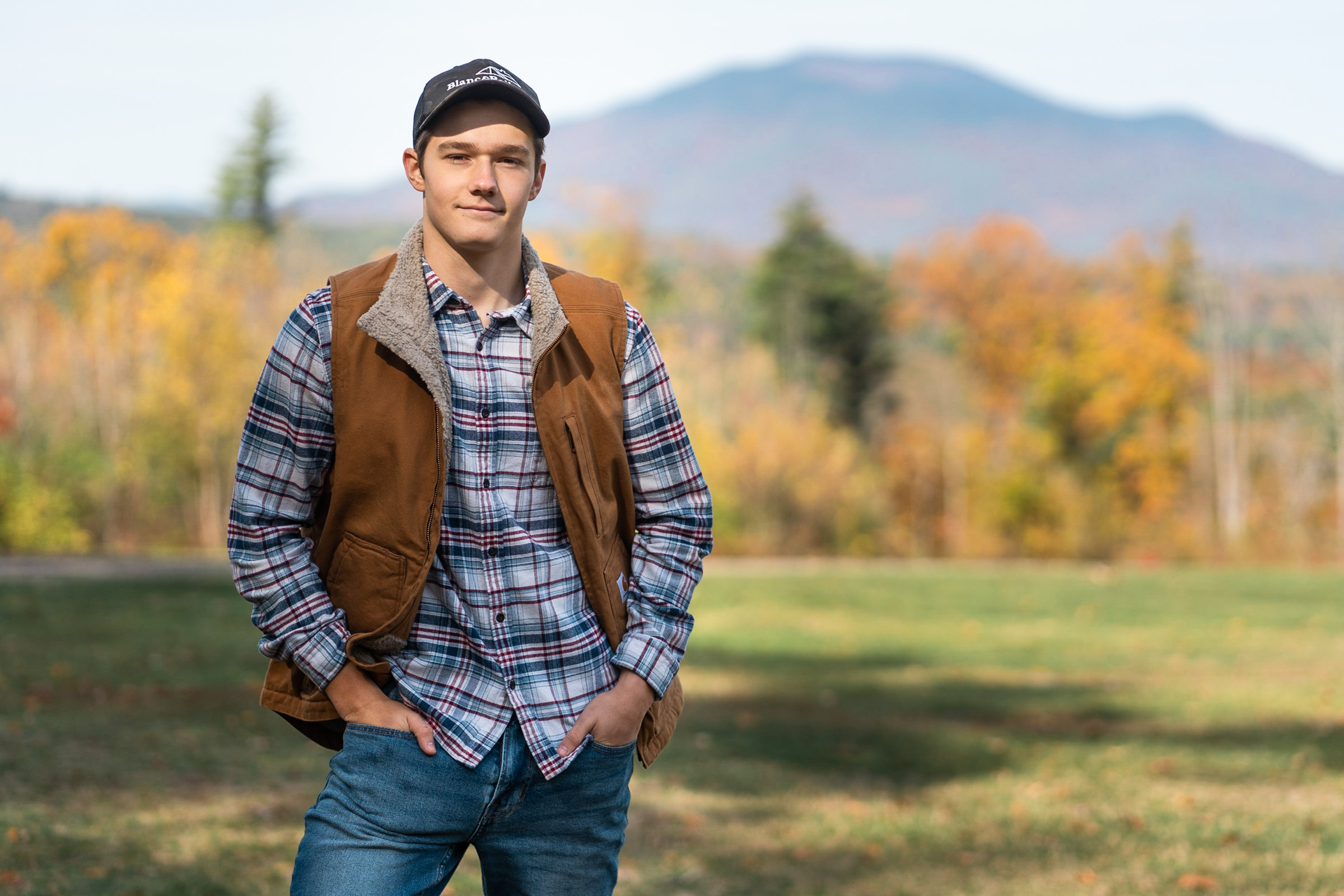 boy standing in front of mount ascutney for high school senior portrait