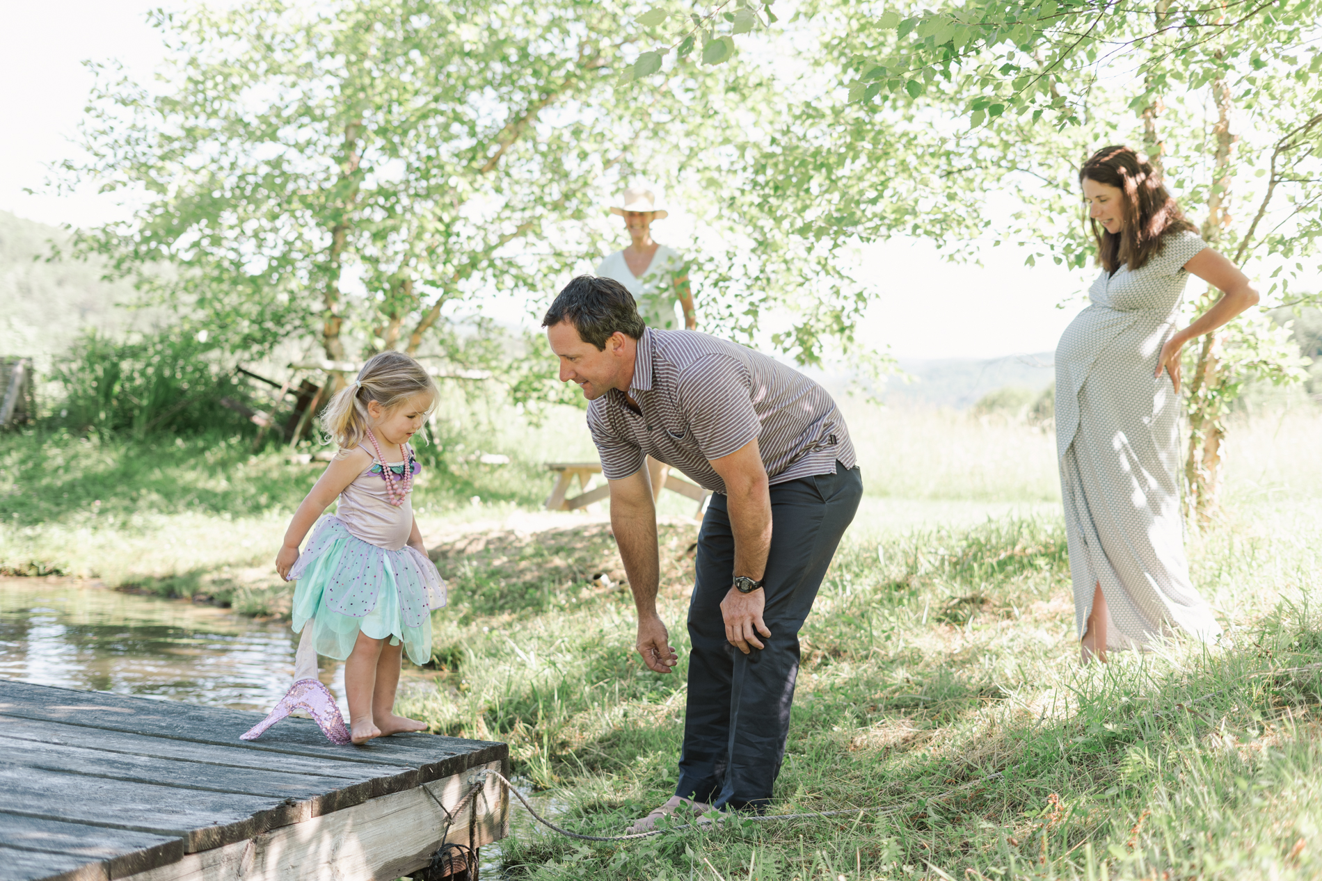 family standing under trees near doc