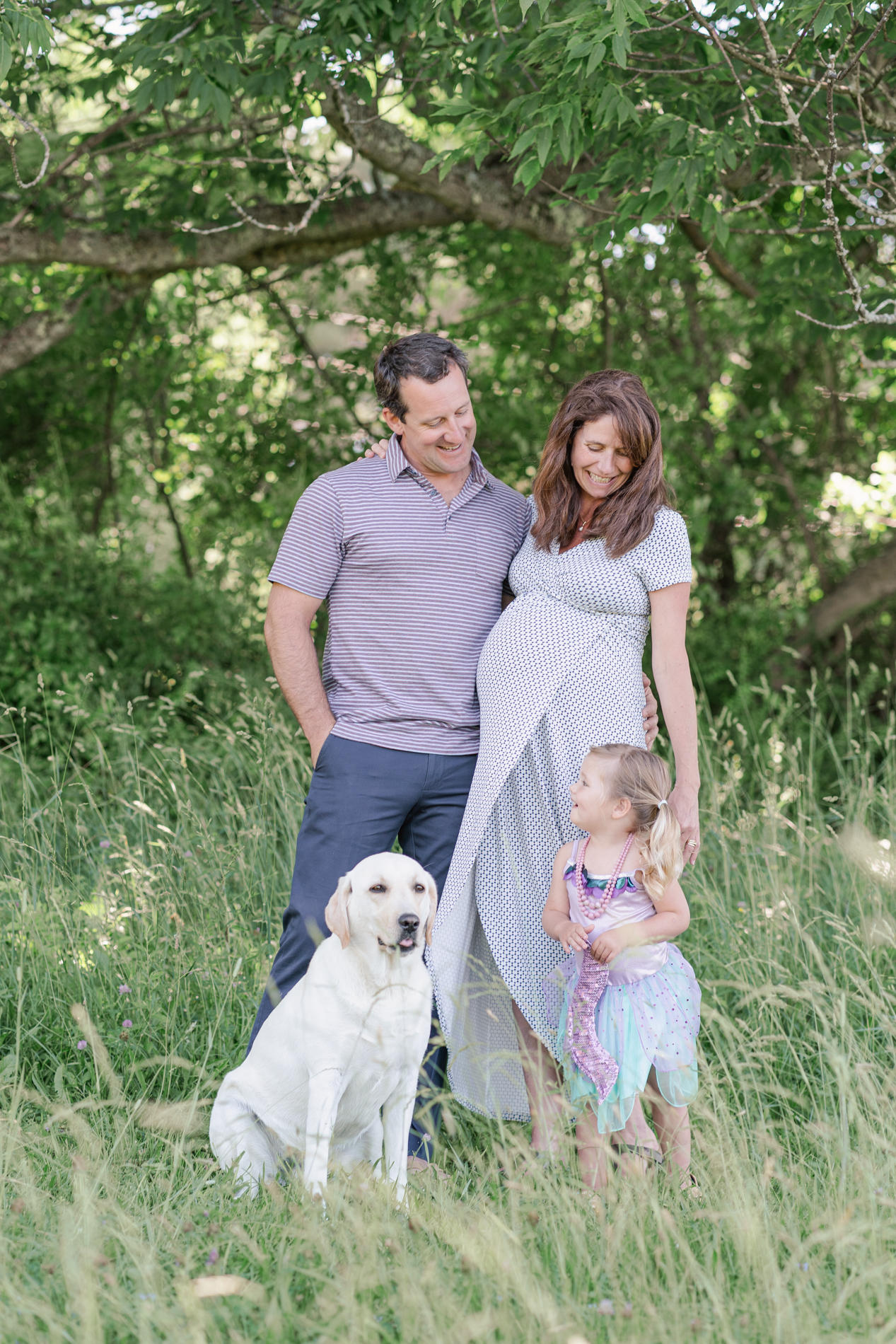 Expecting mom posing with family and dog