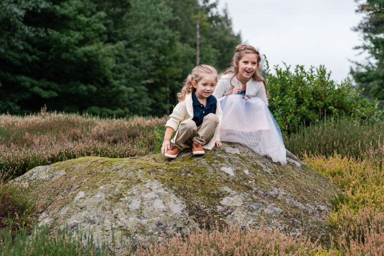 sisters sitting on stone outcropping at The Fells
