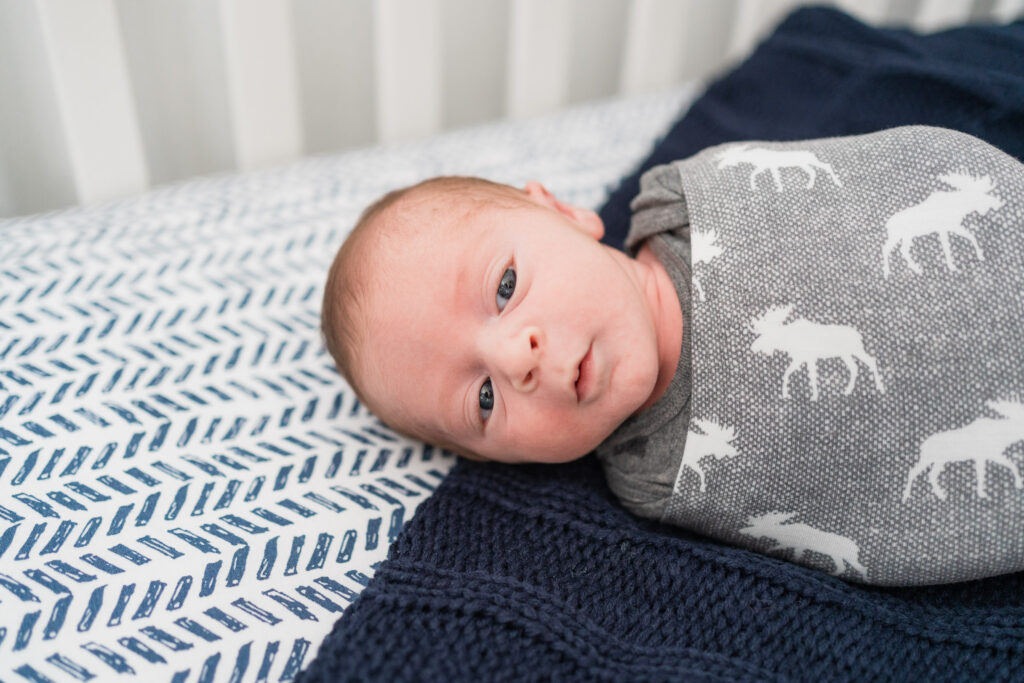 portrait of baby swaddled in crib