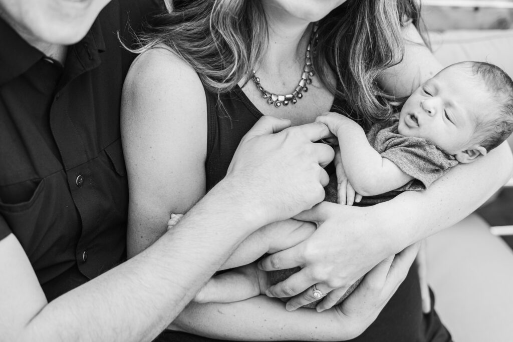 parents holding babies finger
