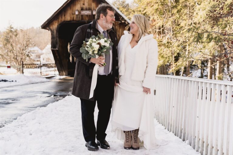 Couple standing on walkway near covered bridge in woodstock vermont