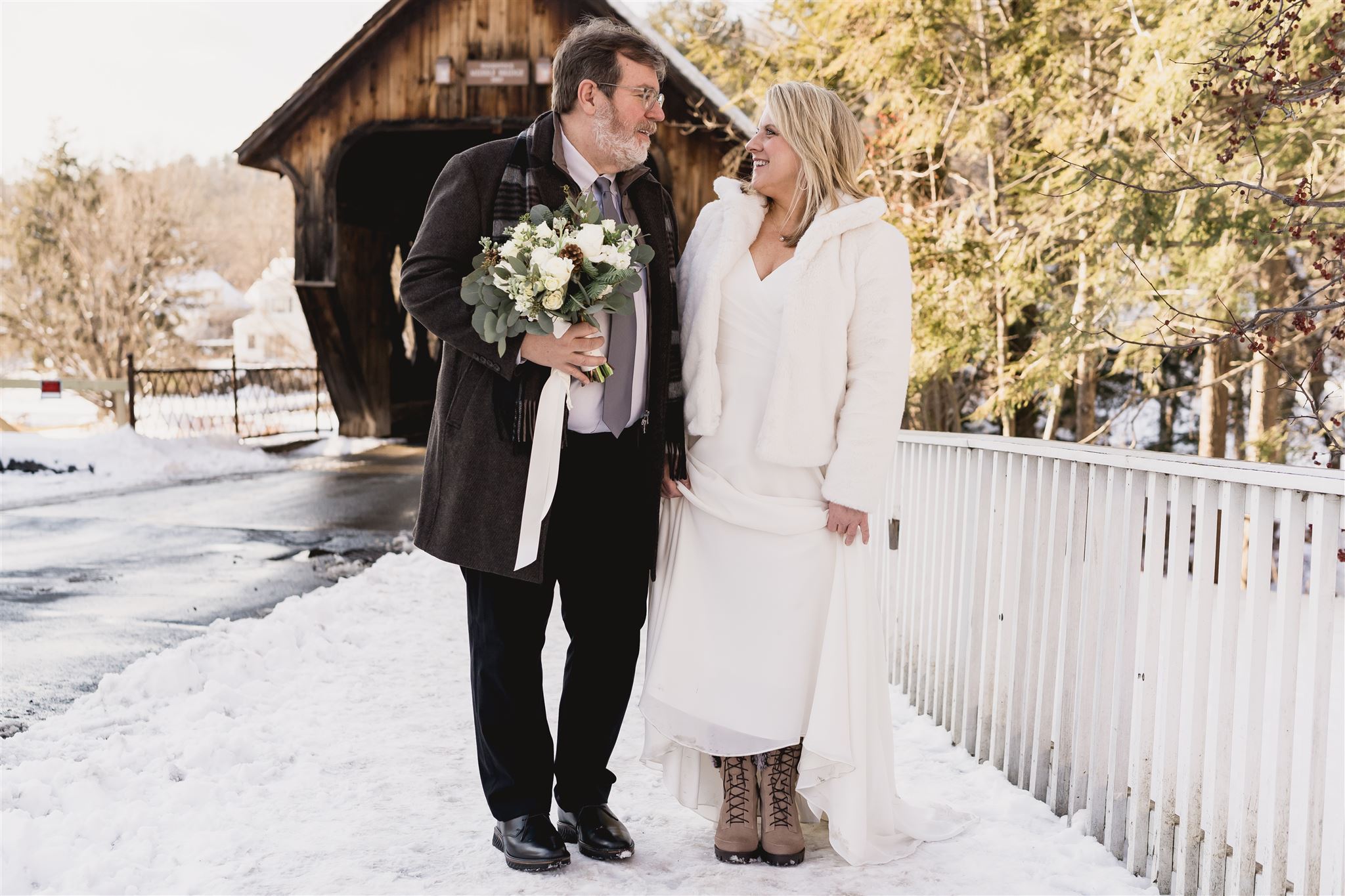 Couple standing on walkway near covered bridge in woodstock vermont