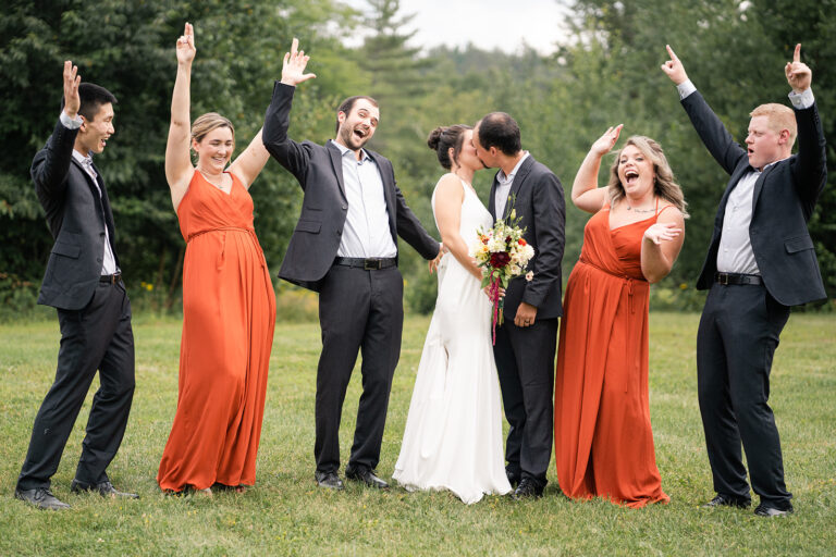 bridal couple cheers in fall dresses as couple kisses