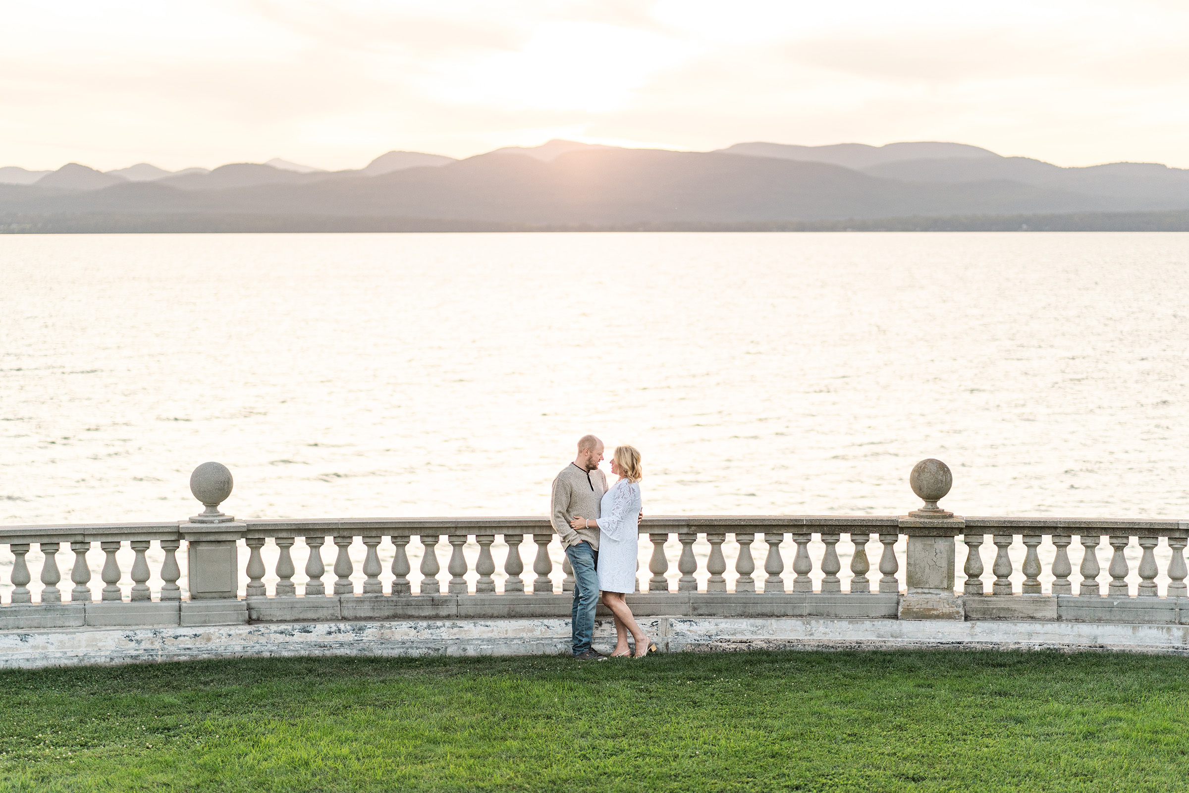 couple standing near view of lake champlain at shelburne farms during engagement session