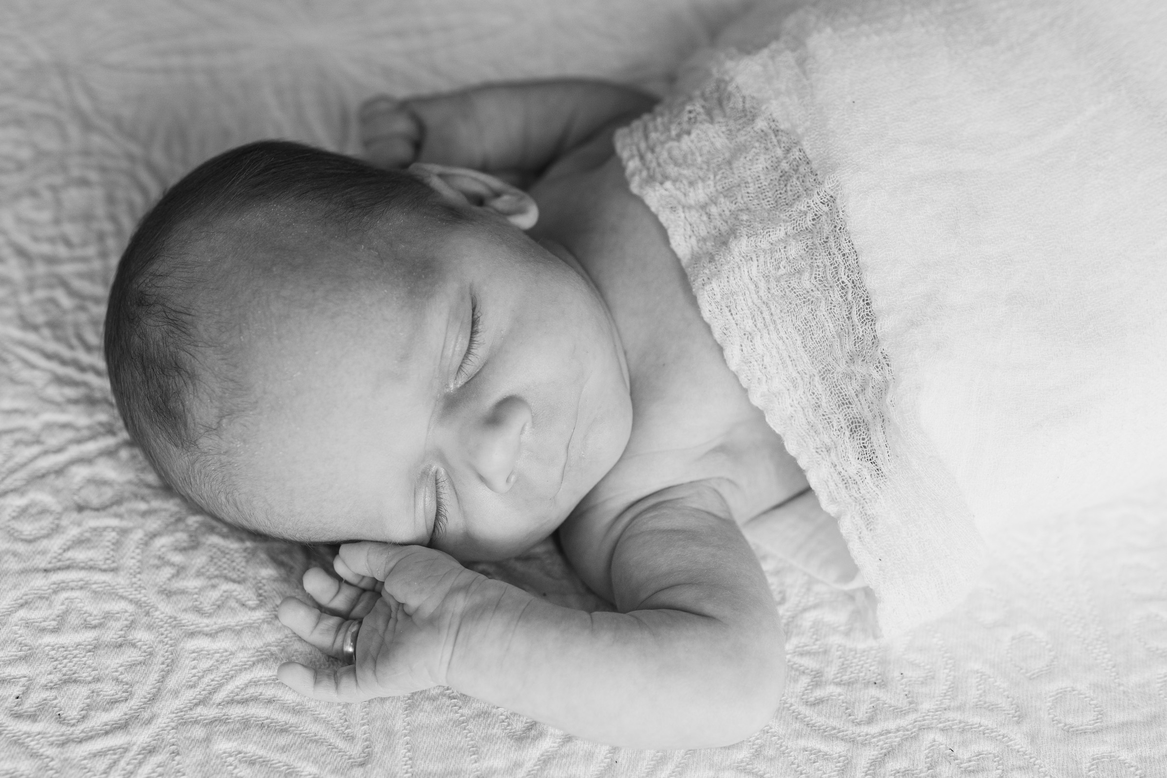 image of baby sleeping with hands up near ears
