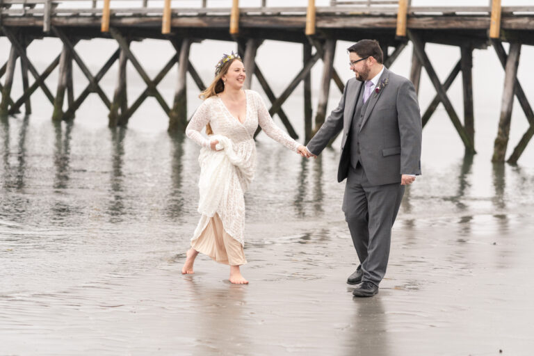bride runs over to groom, under pier at Fort Foster, in Kittery Maine