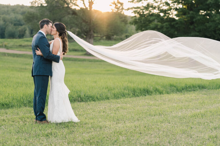 Bride and Groom at Vermont Farm wedding veil shot at sunset