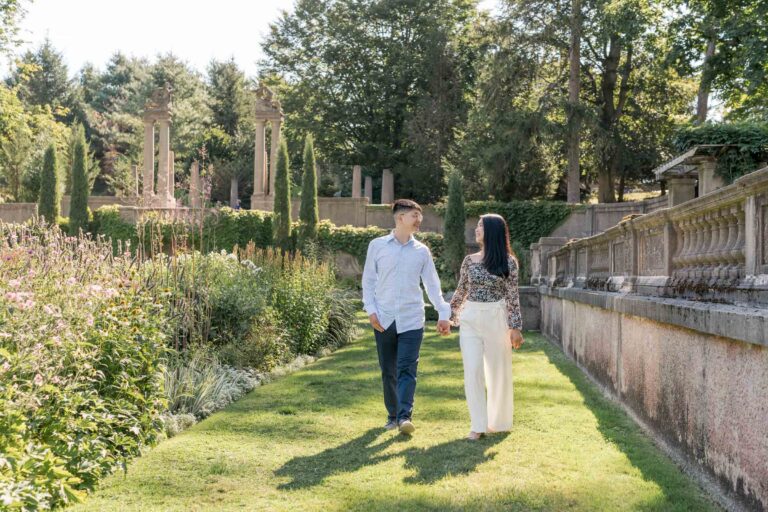 couple walk through garden during engagement session at castle hill on the crane estate