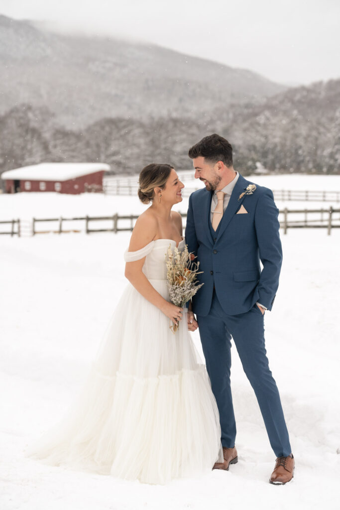 bride and groom smiling and laughing at each other for first look portraits
