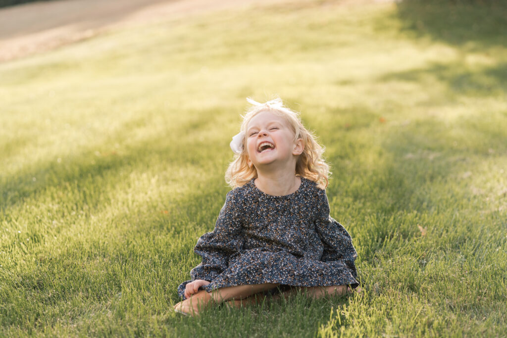 child laughing in the grass