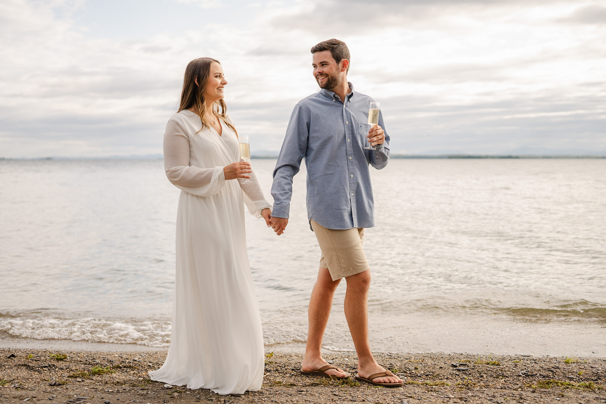 couple walking on beach during lake champlain engagement session, vermont