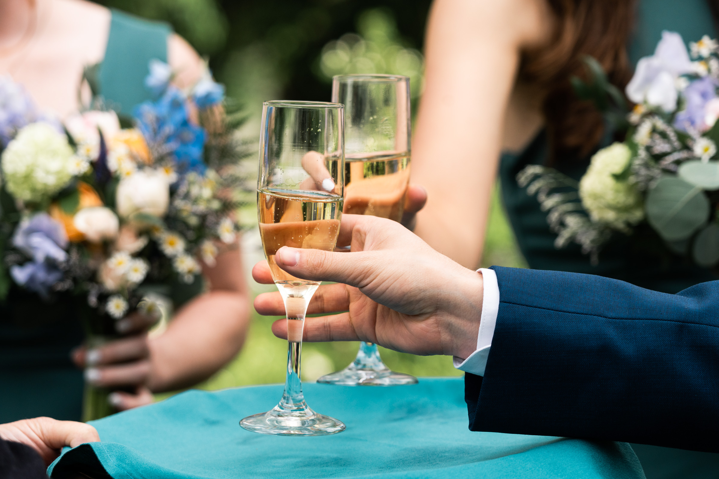champagne glasses cheers with bridesmaids in the back
