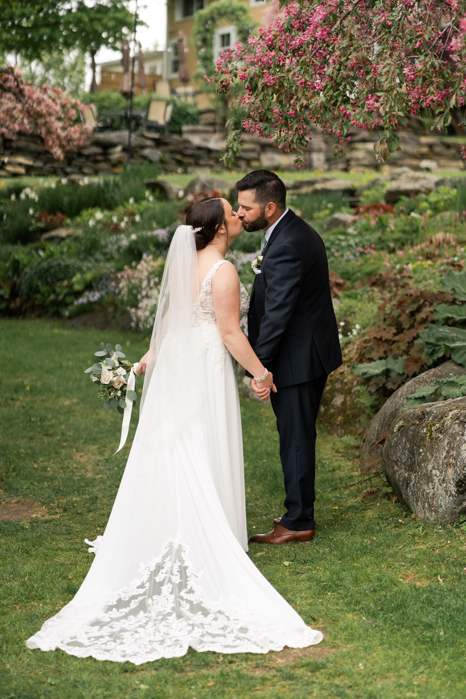 Couple kissing in garden at inn at round barn farm, spring blooms