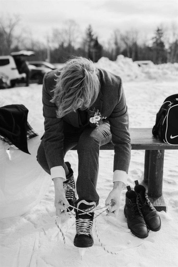 groom tying skates at mountain top inn, chittenden, vt