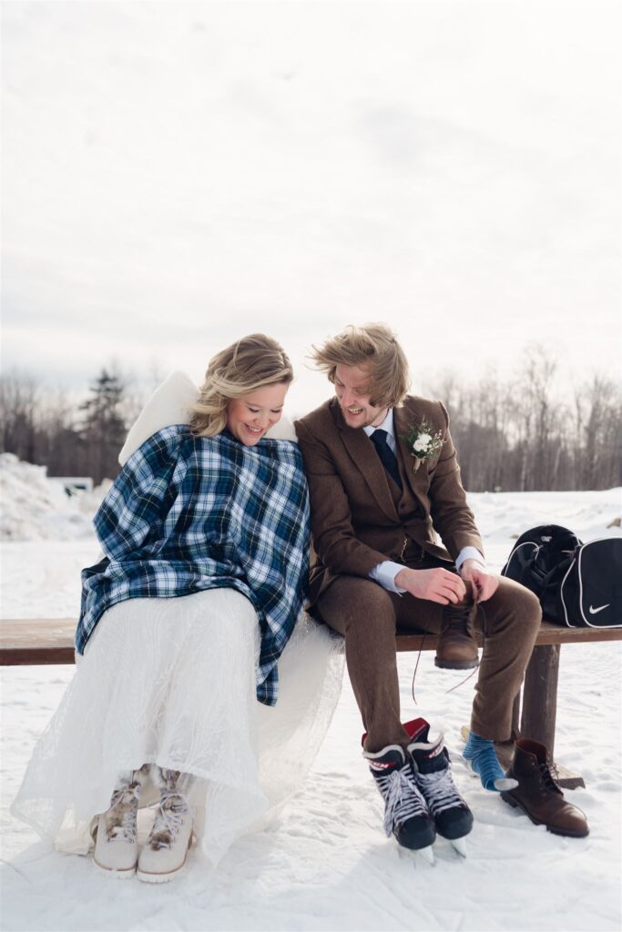 couple seated, taking off skates, wrapped in vermont flannel blanket at mountain top inn, chittenden, vt