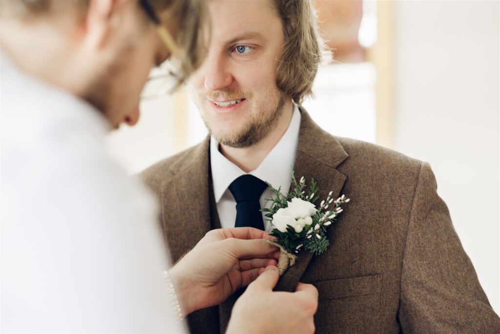 best man putting on boutonnière at mountain top inn, chittenden, vt