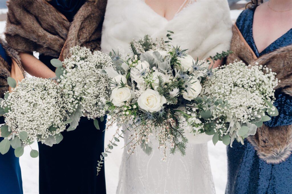 wedding party holding bouquet of flowers at mountain top wedding