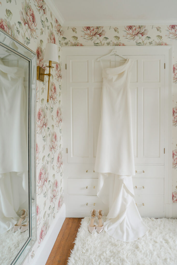 Beautiful dress hanging against floral wallpaper