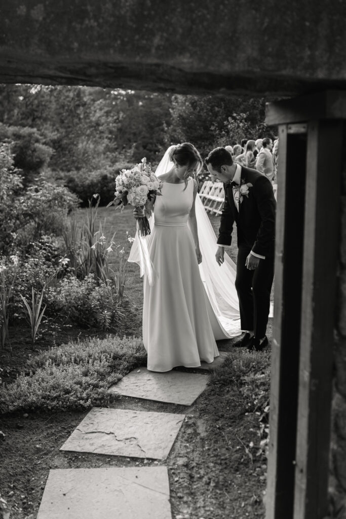 groom helping bride through entry way at The Fells in NH