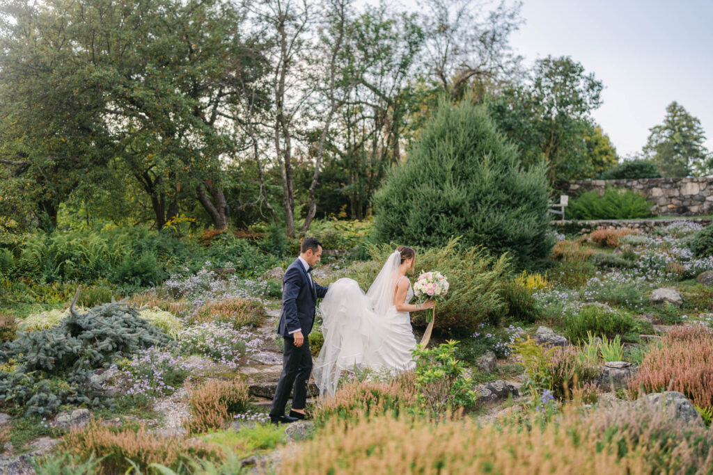 bride and groom walking through fells garden in newbury nh