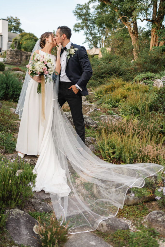 bride and groom standing in the garden at The Fells in Sunapee NH
