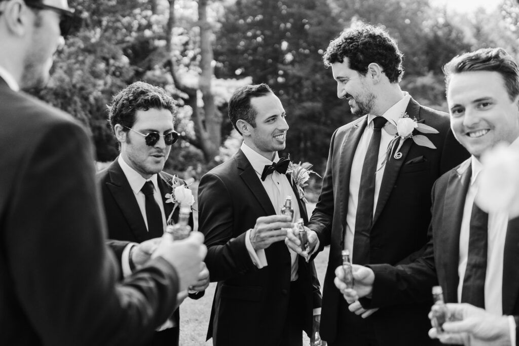 groomsmen sharing a toast outside at the fells