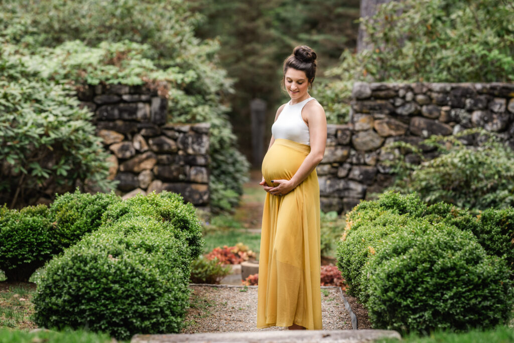 beauitful pregnant woman wearing white and yellow in a garden